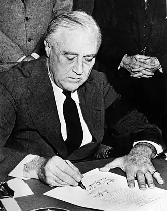 Roosevelt signing the declaration of war against Japan on December 8, 1941