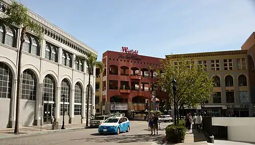 View southwest towards main entrance (red-orange colonnade in center), from Broadway Circle (2016)