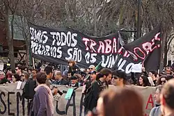 Crowd with banner in the Geração à Rasca demonstration in Lisbon, 12 March 2011.