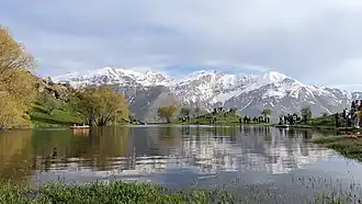 Lake surrounded by snowy mountains in the background.
