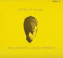 A flat yellow background with a strange mask-like image in the middle and the band name and album title printed in distressed, typewriter font.