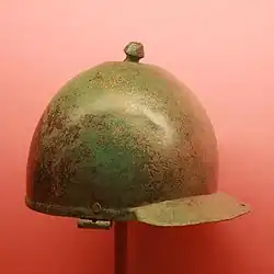 a photograph of an inverted, polished, slightly tarnished, battered, bronze hemisphere