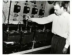 Herbert J. Reed of the Electrochemistry Section measuring specific gravity on a battery