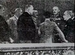 blurred and doctored press photograph showing a group in a box in a concert hall