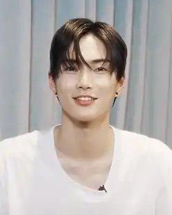 Seunghan looking directly at the camera and smiling.