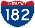 Highway marker for Interstate 182, comprising a wide blue shield with a red, three-pointed crown