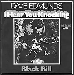 Single cover sleeve with black & white photo of Edmunds playing an acoustic guitar