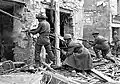 A Canadian soldier fires on the enemy in a house in Caen, July 10, 1944.