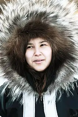 Inuk woman wearing parka with traditional large ruff of irregular fur