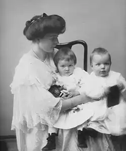 Photograph of a woman holding two young children on her lap