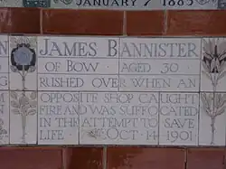 A tablet formed of five tiles of varying sizes, bordered by yellow and blue flowers in an art nouveau style