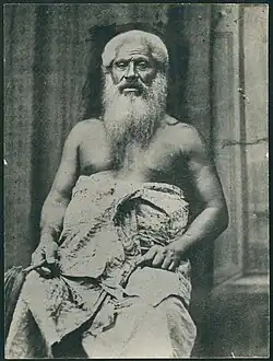 A black-and-white photograph of Joeli Bulu as an elder. He is shirtless with a cloth around his abdomen, has white hair and a large beard.