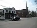 The intersection of Main and Portland Streets, looking west. The site of Susan Kinghorn's millinery is now a Rosemont Market & Bakery. The steeple belongs to the First Parish Congregational Church