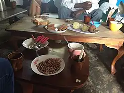 Image 9Mahamri/mandazi (Swahili doughnuts) served with roasted groundnuts (peanuts), tubers, white bread, and chai (from Culture of Kenya)