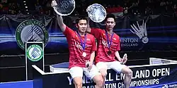 Marcus Fernaldi Gideon and Kevin Sanjaya Sukamuljo pose at the 2017 All England Open podium