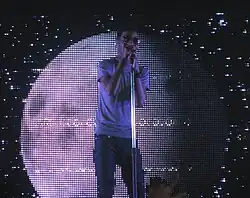 Kid Cudi performs in front of a moon in 2009.