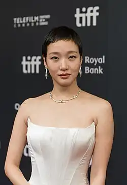 Kim wearing a white strapless dress and looking at the camera at the 2024 Toronto International Film Festival