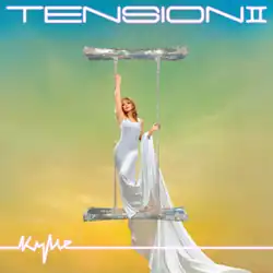 An image of Kylie Minogue wearing a long, plain, body-hugging white dress standing inside of a large, silver Gemini symbol covered in crystals. The album title is displayed on the upper side, while the name "Kylie" on the lower left side of the image. The cover's background is a color gradient transitioning from teal at the top through green to yellow at the bottom.