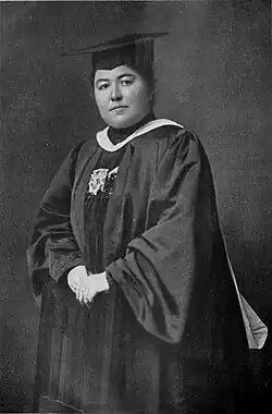 A white woman wearing academic regalia