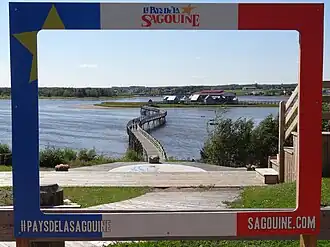 A footbridge leading to an island with a group of buildings