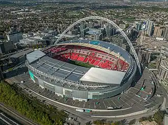 Aerial view of large stadium with an arch spanning the roof.