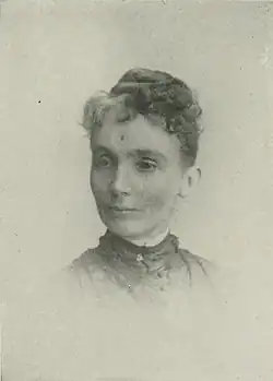 19th-century B&W portrait photo of a woman with her hair in an up-do, wearing a dark, high-collared blouse.