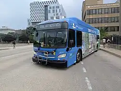 A blue bus with children's artwork on the side for earth day
