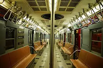 Older NYCTA R30 train carriage has two rows of pivoted grab handles