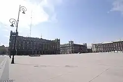 A square with three buildings in the background. The entrance to Zócalo/Tenochtitlan station is located at one corner of the square.