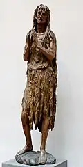 Wooden statuette of an elderly woman doing penance