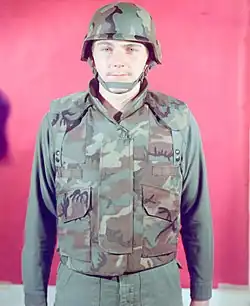 A man in 1975 modelling an early ERDL-patterned prototype of the PASGT vest, with two PALS webbing strips on the front.