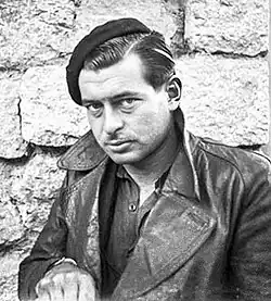 Portrait of Massana, a white man wearing a beret and a leather jacket.
