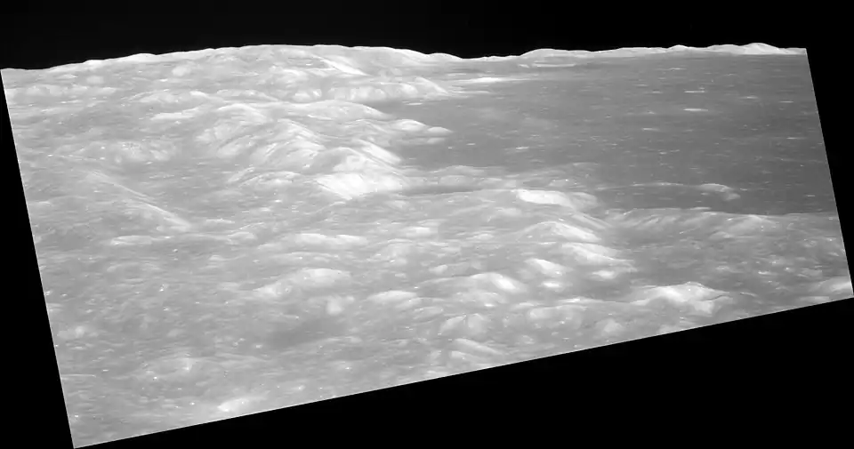Low-altitude view of southern Mare Crisium from Apollo 11, facing northwest and showing the crater Shapley near center at the edge of the mare, and the distal wall of the crater Greaves near the horizon