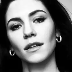 A black-and-white photograph of Marina Diamandis' face.