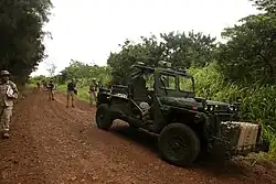 Marines follow a Ground Unmanned Support Surrogate (GUSS), experimental technology being tested by the Marine Corps Warfighting Lab during RIMPAC 2014 at Kahuku Training Area.