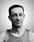 black-and-white image of Max "Marty" Friedman wearing a jersey/tank top, smiling thinly and looking just left of camera