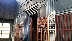 Decorated black door to a black structure.