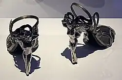 High-heeled shoes whose heels are formed into winged humanoid figures