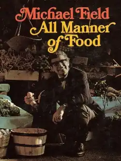 middle-aged man, with full head of neat, curly hair, wearing a suit, bow tie and glasses, seated among baskets of vegetables