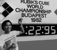 Minh Thai standing next to the timer after setting his 22.95 world record single
