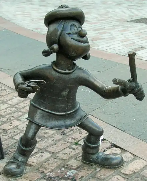 Image 52Statue of Minnie the Minx, a character from The Beano. Launched in 1938, the comic is known for its anarchic humour, with Dennis the Menace appearing on the cover. (from Children's literature)