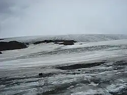 A continuous mass of glacial ice protruded by a few rock outcrops