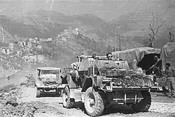 Reconnaissance car going uphill, followed by another car