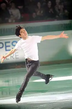 A photograph of Nathan Chen skating during an exhibition under colourful lights.