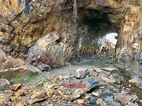 2018 photograph of Needle's Eye Tunnel, near the summit of Rollins Pass. This view shows the northeast portal in the foreground; the southwest portal can be seen in the background. Wire mesh and metal dowels were installed in August 1987 to help reduce additional rock falls and preserve the condition of the tunnel constructed in 1903 (122 years ago) (1903).