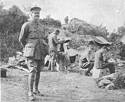 Unarmed soldiers and officers rest behind a ridge