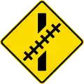 Railway crossing ahead at an oblique angle