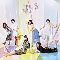 6 women pose with the large-size colorful cellophanes. The top of the cover shows the title "ごめんねFingers crossed" and the group's name "乃木坂46" in purple font.