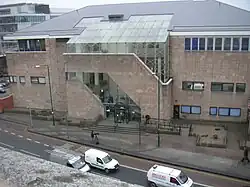 Elevated view of a light coloured building alongside a road