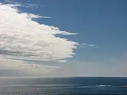 The hue of the reflected sky contributes to the perceived azure color of water, but most of the cyan color comes from the intrinsic color of water scattered back up to the surface by small suspended particles.